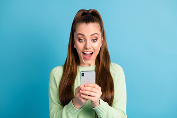 Close-up portrait of her she nice attractive pretty amazed overjoyed focused cheerful cheery brown-haired girl using device browsing news isolated bright vivid shine vibrant blue color background