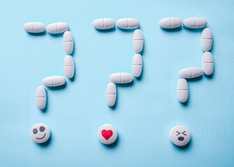 question mark made of white pills on a blue background. treatment choice and idea and question concept.