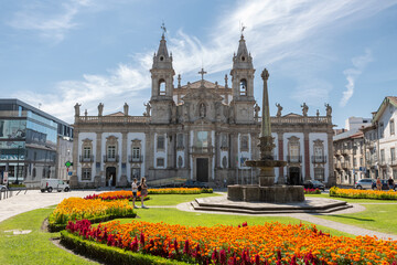 View at the iconic Saint Marcos church building, hotel Vila Galé, fountains and garden with a tourist couple visiting