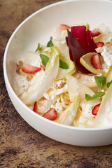 Endive salad with goat cheese, strawberry and walnuts.