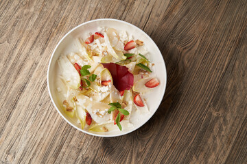 Endive salad with goat cheese, strawberry and walnuts.