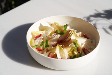 Endive salad with goat cheese, strawberry and walnuts.