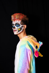 Young man in unicorn pajama with skull face make-up