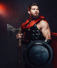 Warlike and armoured rome empire fighter with beard and muscular build posing holding shield and...