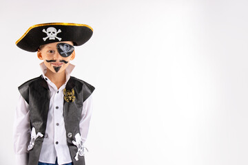 Halloween party. A little boy in a pirate costume and a makeup on his face is having a good time at the Halloween party. Face painting kids. Isolated white background with empty space.