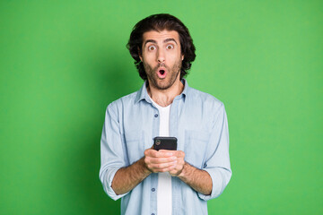 Portrait of his he nice attractive amazed cheery mature guy using device app 5g comment feedback reaction pout lips isolated over bright vivid shine vibrant green color background