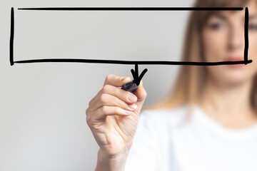 Young woman holds a blue marker and writes something on a light background. Banner. Concept business, company, work, business strategy