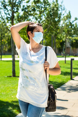 health, safety and pandemic concept - sad senior woman wearing protective medical mask for protection from virus walks