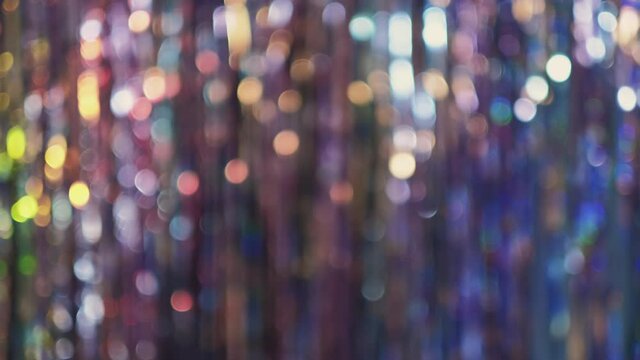 Christmas abstract background. Colorful bokeh light. Winter holidays festive decor. Blur sparkling iridescent glow motion. Vintage glitter tinsel texture. New Year party night rainbow sparks.