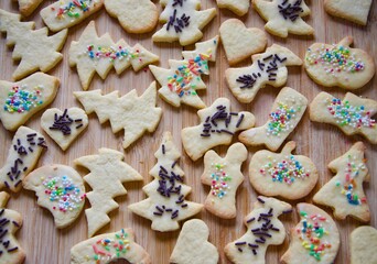 Traditional homemade German Christmas cookies on a wooden board, many butter biscuits with multicolored granulated sugar, different figures 