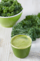 kale juice in a glass on white surface