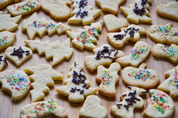 Traditional homemade German Christmas cookies on a wooden board, many butter biscuits with multicolored granulated sugar, different figures
