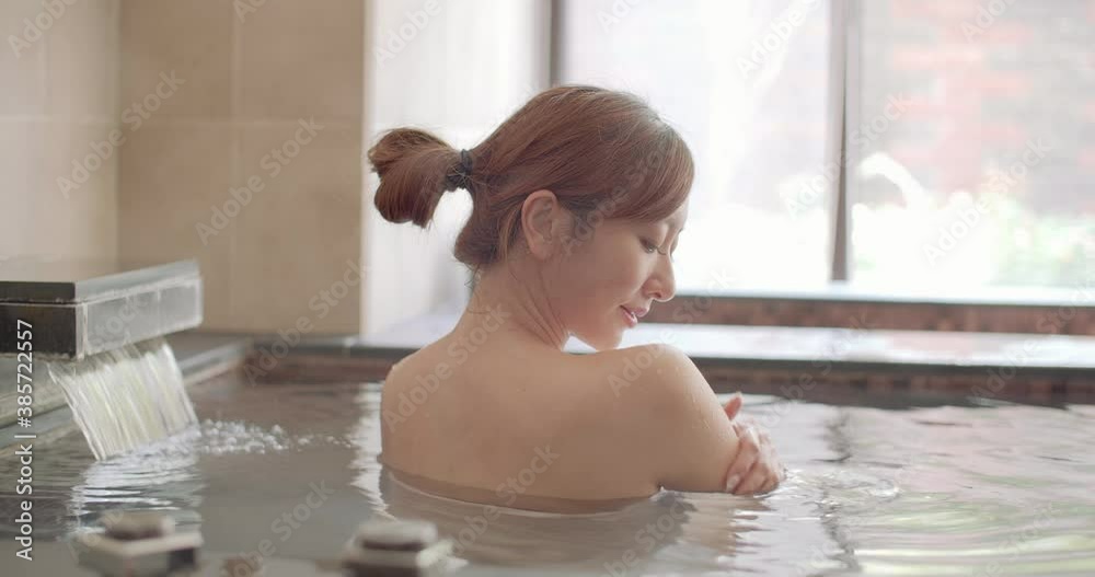 Poster Asian Young woman relaxing and massaging in hot spring

