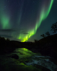 Beautiful night sky with Aurora Borealis aka northern lights in the fjords in Norway.