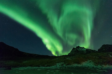 Beautiful night sky with Aurora Borealis aka northern lights in the fjords in Norway.