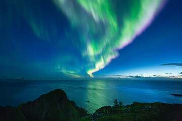 Beautiful night sky with Aurora Borealis aka northern lights in the fjords in Norway.