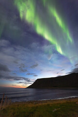 Beautiful night sky with Aurora Borealis aka northern lights in the fjords in Norway.