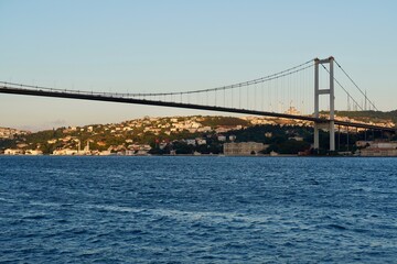 Tourist boats sail under the bridge in Istanbul. Traveling on the Bosphorus. Panoramic view, View of the First Bosphorus Bridge sailling Bosporus.