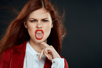 Pretty woman with long hair red jacket makeup lips charm dark background