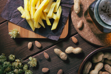 French fries beer and nuts top view background closeup pub