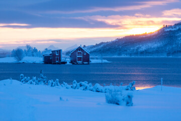 Moody sky winter sunset blue hour over the red houses in Norway