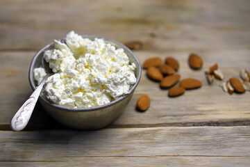 Fresh homemade cottage cheese in a bowl. Almond. Country style. Healthy food concept. Dairy.