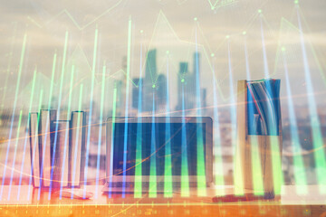 Stock market graph on background with desk and personal computer. Multi exposure. Concept of financial analysis.