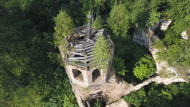 Beautiful aerial view of an Orthodox Church and surrounding forest. Clip. Top view of ruined and abandoned chapel located in dense green forest.
