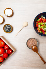 Salad with celery, tomatoes and tuna. Salad ingredients on a light wooden table top view
