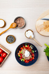 Salad with celery, tomatoes and tuna. Salad ingredients on a light wooden table top view