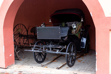 Fototapeta na wymiar Old carriage near the pink house
