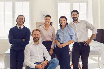 Group portrait of smiling businesspeople with business trainer in modern office