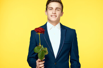 Gentleman in classic suit on yellow background with red rose romance 