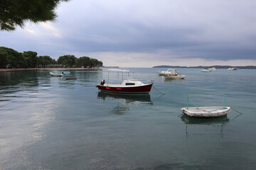 Calm sea before a thunderstorm, gray rain clouds and blue calm sea, boats at anchor, Adriatic, Croatia