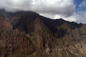High steep cliff. Landscape with misty mountain peaks and a sheer cliff. Caucasus, Russia. 