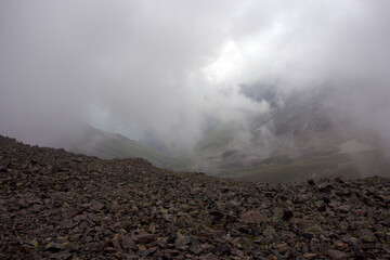 Alpine pass in the fog. View from Northern Shirman Pass, Caucasus, Russia. Height 3450 meters above sea level.