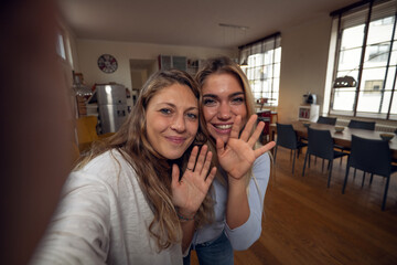 A happy smiling family is making a selfie or video call to friends or relatives while having a...