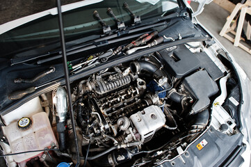 Car repair and maintenance theme. Open hood engine in auto service.