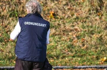 Naklejka premium Konzept Ordnung und Sicherheit: Mitarbeiter des Ordnungsamtes auf Streife und kontrolliert - selektiver Fokus, sehr viel Copyspace