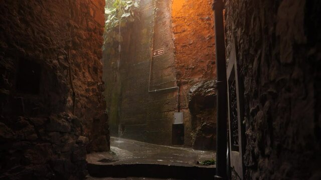 Water pouring down in the street of an Italian village during heavy rainfall.