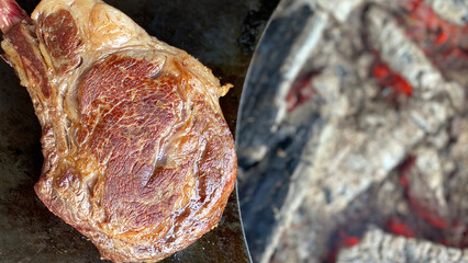 Griled Tomahawk rib beef steak  on open flame. Top view, space for text