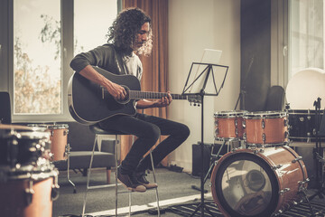 Black Man Artist Sit and Play Melody on Guitar .