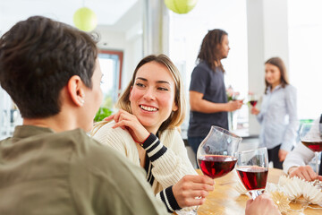 Two women as friends at a celebration toast with red wine