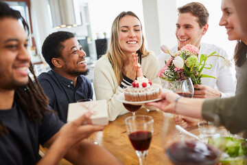 Woman celebrates birthday with friends and cake at home