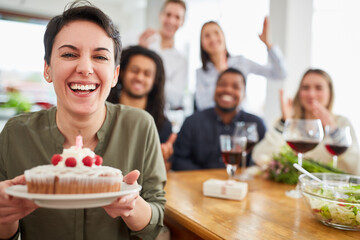 Woman with cake and blown out candle at birthday party