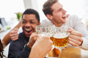 Cheering men drink beer and toast themselves while watching football