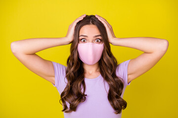 Close-up portrait of attractive scared worried wavy-haired girl wearing safety mask omg isolated over bright yellow color background
