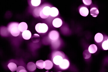 Christmas lights. Bokeh glows on a dark background. Christmas garlands with a blurred focus in the form of lilac bokeh.
