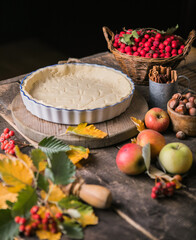 Baking background with raw traditional classic apple pie, bake  ingredients and utensils. Homemade  cake surrounded by fresh fruits