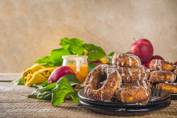Autumn sweet dessert recipe. Homemade apple cider donuts. Baked donuts with sugar, cinnamon glaze and white sugar topping drizzle, on wooden background with fresh apples